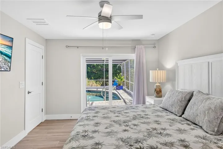 Primary Bedroom featuring access to outside, light wood-style flooring, and a ceiling fan