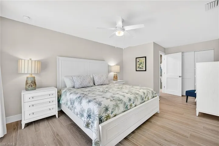 Primary Bedroom with wood tiled floors, ceiling fan, and a closet