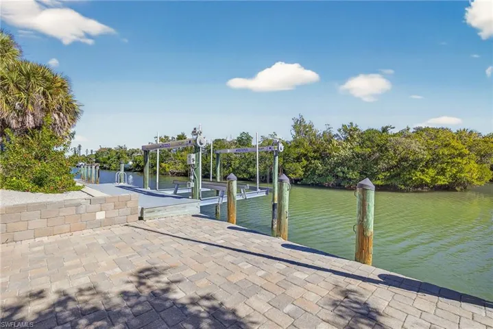 Dock area featuring boat lift and a water view