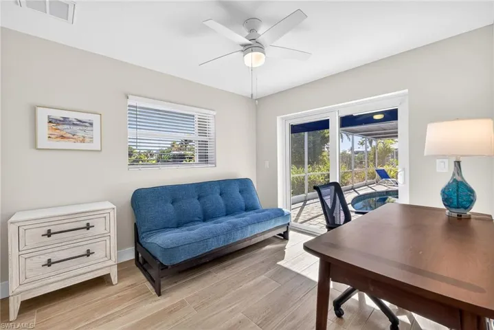Home office with light wood-style floors and ceiling fan