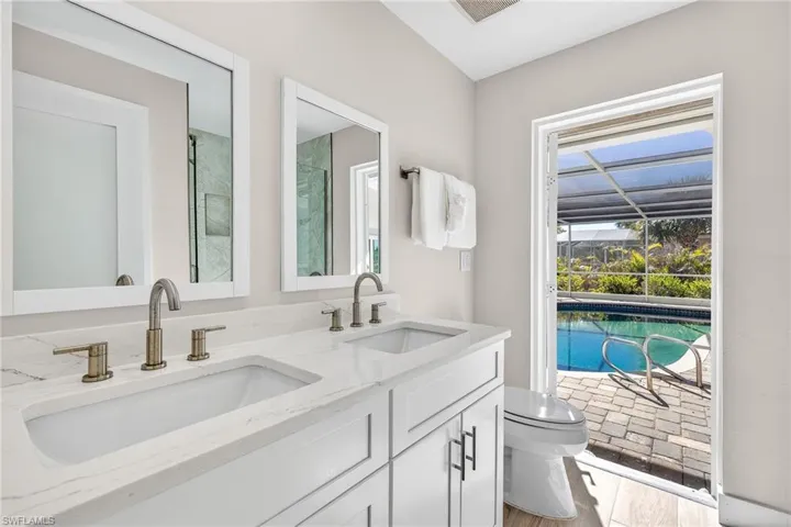 Full bath featuring double vanity, light wood finished floors, and a shower