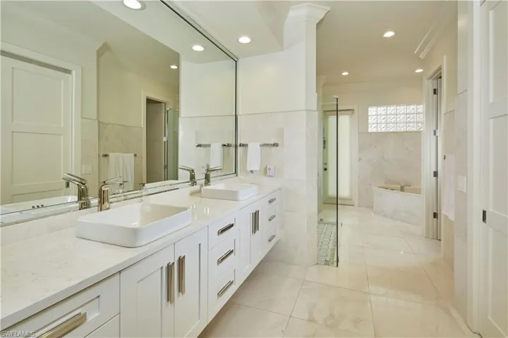 Completely updated en suite primary bath with dual sinks, walk-in shower & soaking tub.