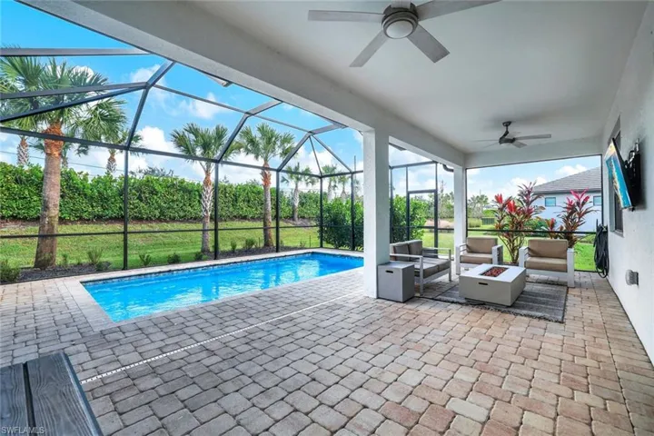View of pool with a patio, a lanai, and ceiling fan