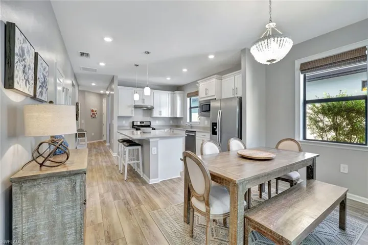 Dining room featuring sink, an inviting chandelier, and light hardwood / wood-style floors