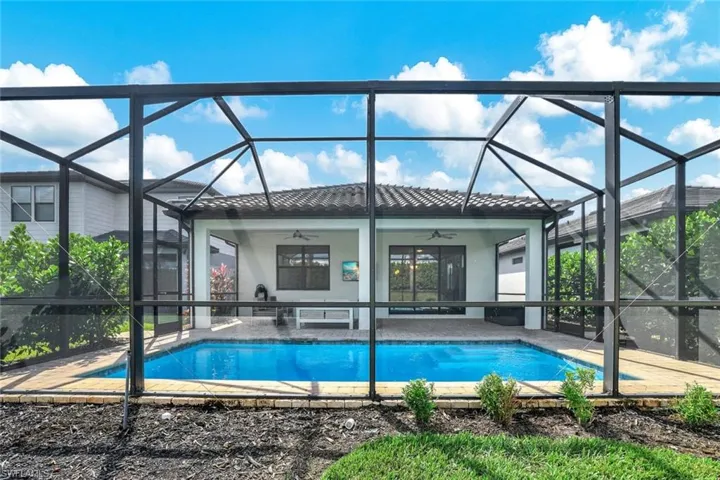 View of swimming pool with a lanai, ceiling fan, and a patio area