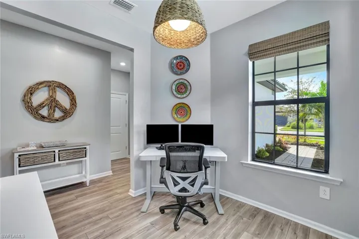 Home office with light hardwood / wood-style flooring and plenty of natural light