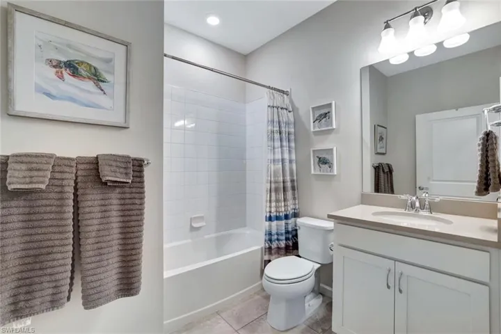 Full bathroom featuring vanity, tile patterned flooring, shower / bathtub combination with curtain, and toilet