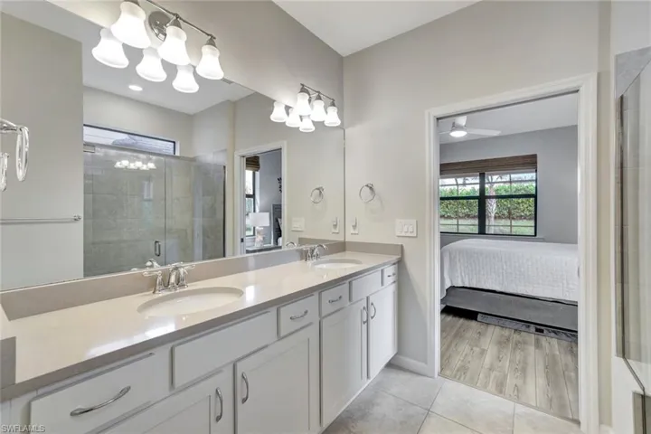 Bathroom featuring hardwood / wood-style floors, vanity, and a shower with door