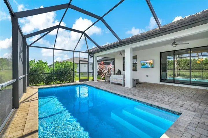 View of swimming pool with a lanai, ceiling fan, an outdoor hangout area, and a patio area