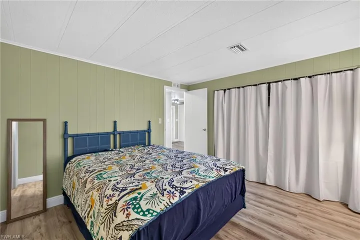 Paneled walls finished in sage green, wood-finish flooring, and recessed ceiling panels