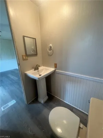 Bathroom with toilet and hardwood / wood-style floors