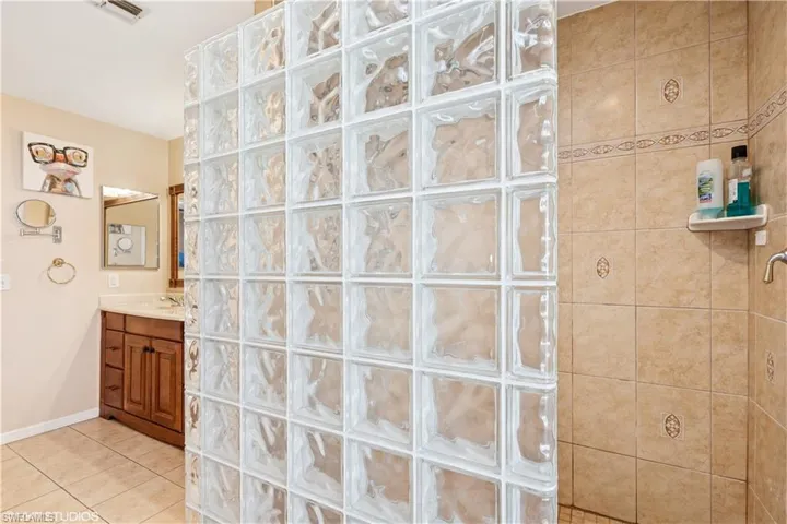 Bathroom featuring vanity, tile patterned floors, visible vents, and walk in shower