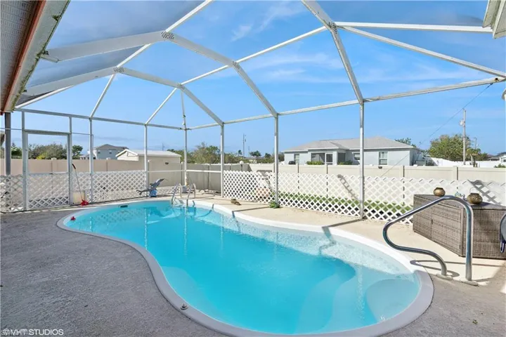 View of pool featuring a lanai, a fenced in pool, a patio, and a fenced backyard