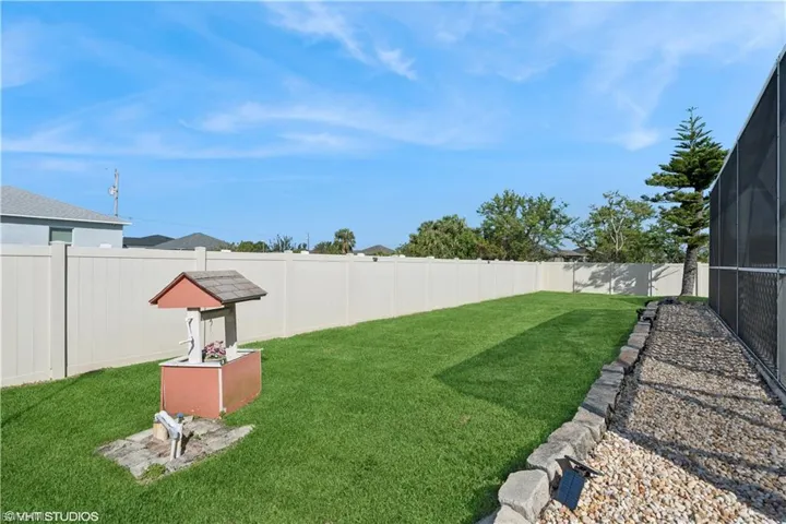 View of yard with enclosure and a fenced backyard
