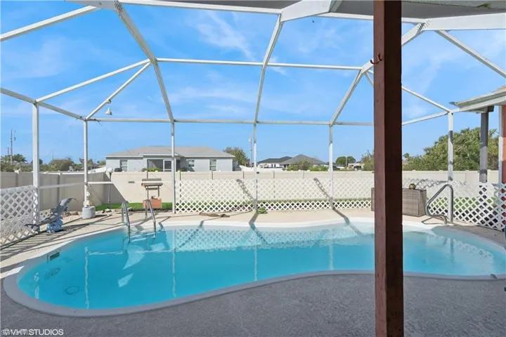 View of swimming pool featuring a lanai, a fenced in pool, a fenced backyard, and a patio area