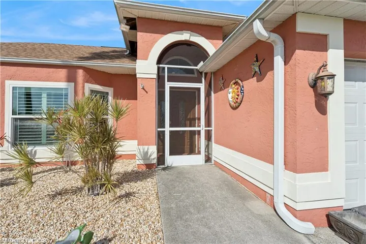 View of exterior entry featuring a garage and stucco siding