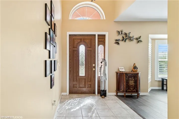 Entryway with light tile patterned floors and baseboards