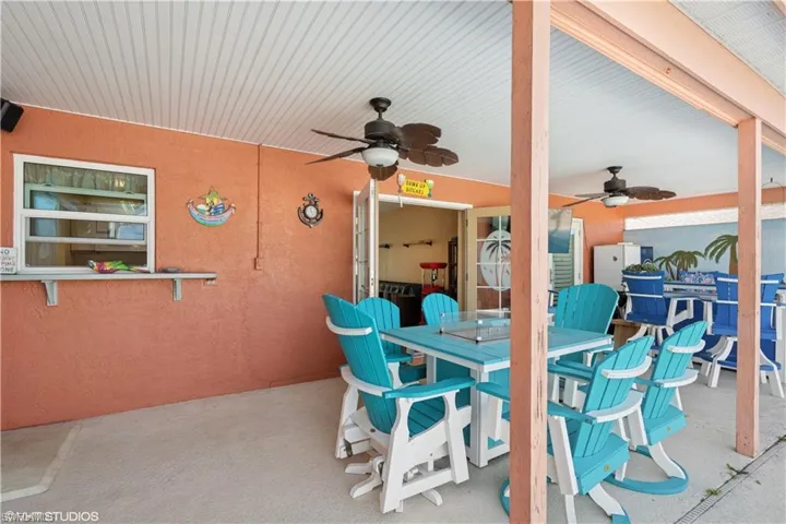 View of patio with outdoor dining area and a ceiling fan