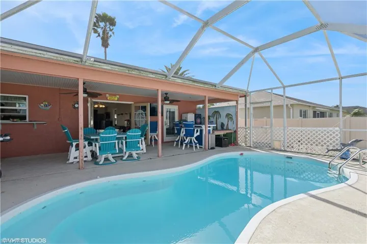 View of swimming pool featuring a fenced in pool, ceiling fan, fence, a lanai, and a patio