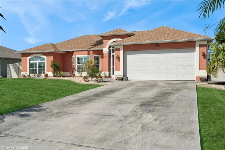 Ranch-style house featuring stucco siding, driveway, a front lawn, roof with shingles, and a garage
