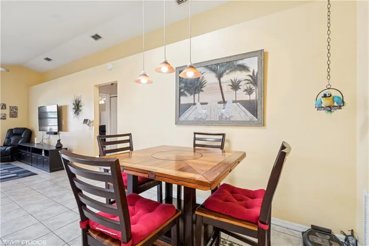 Spacious Kitchen, featuring light tile patterned floors, visible vents, baseboards, and vaulted ceiling