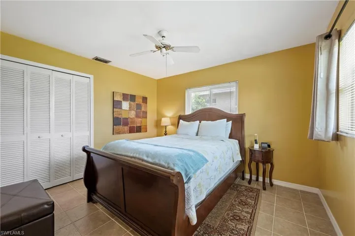Tiled bedroom with a closet, a ceiling fan, and baseboards
