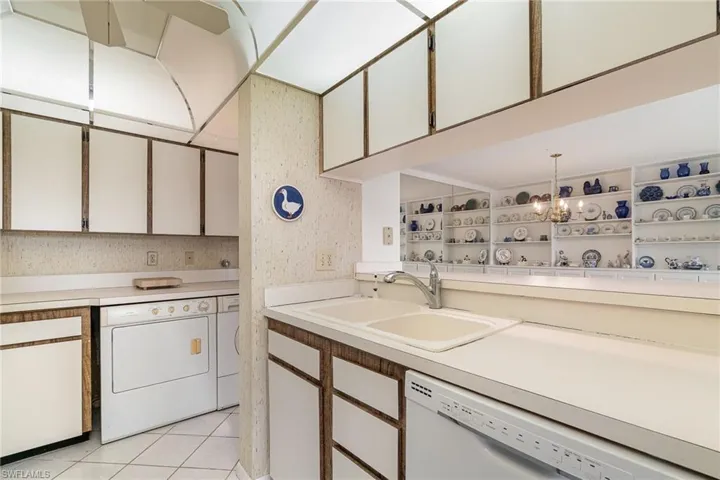 Laundry area tucked under kitchen counters with plenty of storage space to spare
