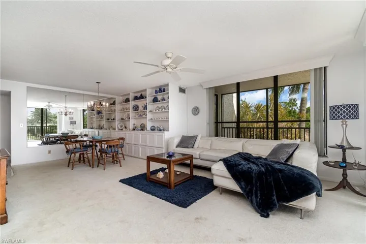 Open floor plan flows in an L-shape with dining and living area off kitchen anchored by den