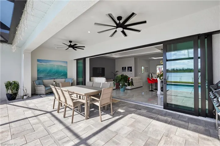 View of patio / terrace with outdoor dining area, a ceiling fan, a water view, and a outdoor kitchen
