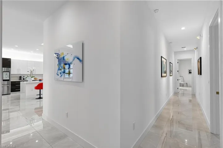 Hall with recessed lighting and light marble finish floors