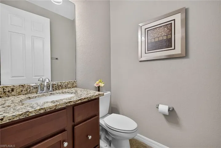 Half bath and vanity with granite countertops on 1st floor.