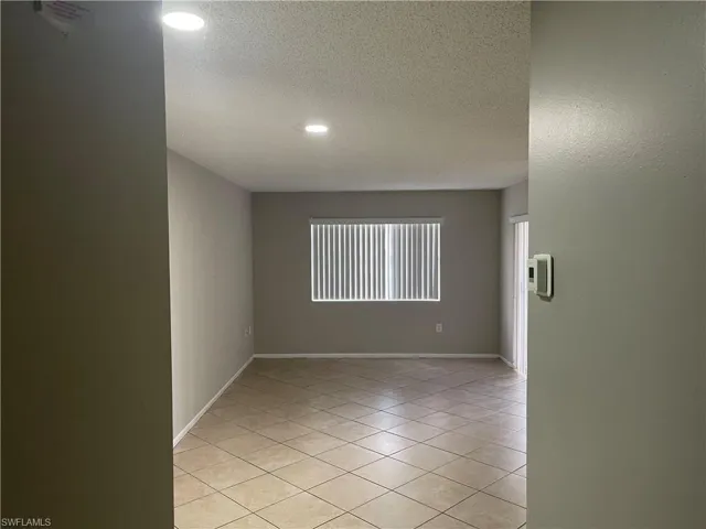 Unfurnished room featuring light tile patterned flooring, a textured ceiling, and recessed lighting