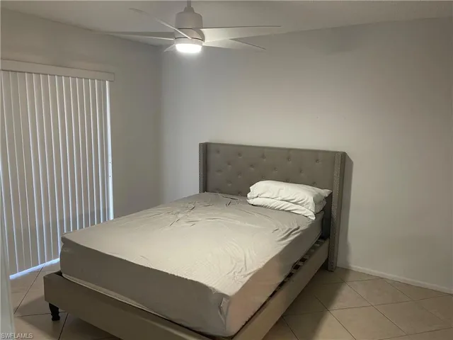 Bedroom featuring light tile patterned floors and ceiling fan