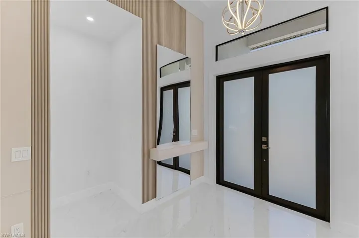 Foyer entrance with an inviting chandelier and french doors