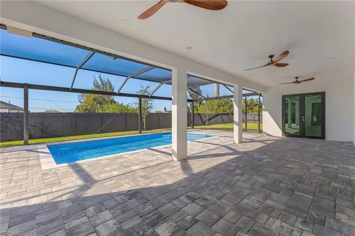 View of swimming pool with ceiling fan, a lanai, and a patio