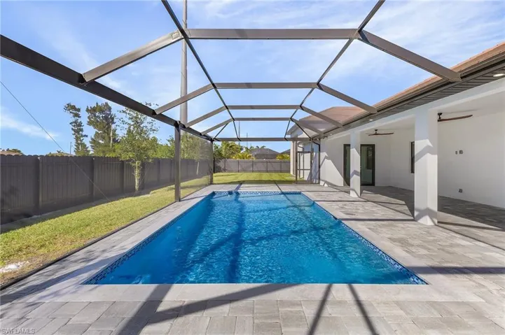 View of swimming pool featuring a lanai, ceiling fan, and a patio area