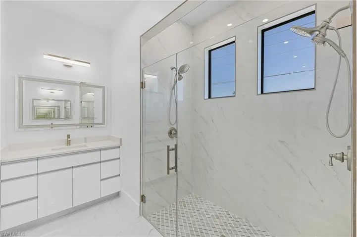 Bathroom with a shower with shower door and vanity