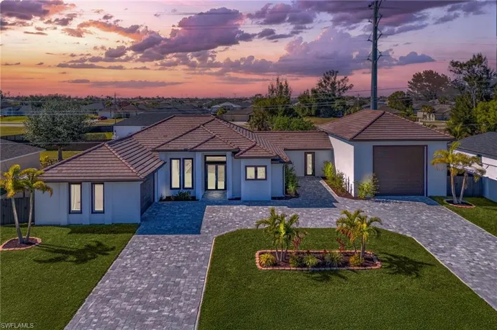 View of front of home featuring a lawn and a garage