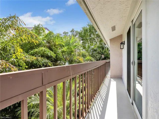 Private balcony with a metal railing and an attached sconce light