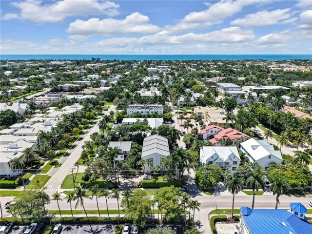 Aerial perspective featuring a residential neighborhood with mature landscaping and clear skies