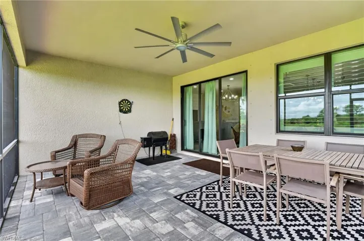 Screened patio featuring paver flooring, a ceiling fan, and sliding glass doors