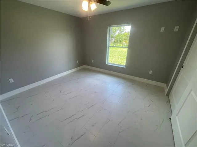 Unfurnished bedroom featuring ceiling fan and light marble finish flooring