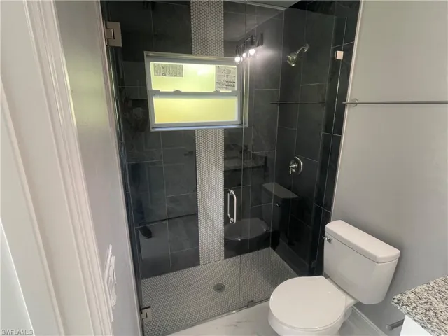 Bathroom featuring vanity, a stall shower, and marble finish flooring