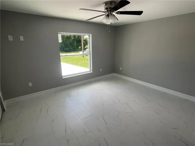 Spare room featuring baseboards and light marble finish floors