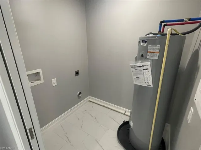 Laundry room with light marble finish floors, water heater, electric dryer hookup, and hookup for a washing machine