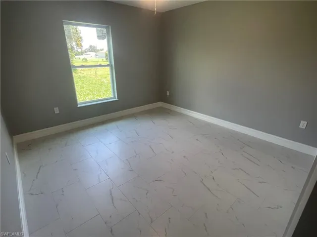 Empty room featuring baseboards and light marble finish floors