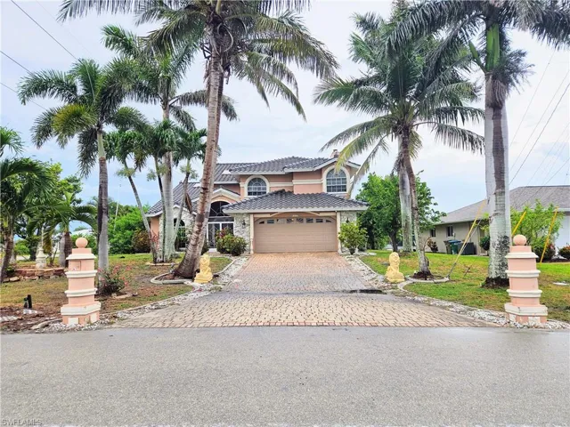View of front of home with driveway, an attached garage, a tile roof, and stucco siding