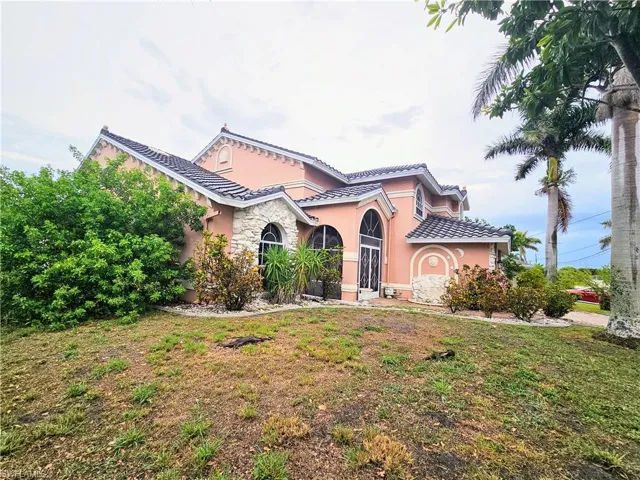 Mediterranean / spanish house with stucco siding, a front lawn, and a tile roof