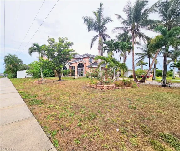 Mediterranean / spanish-style house featuring stucco siding, a front yard, and a tile roof