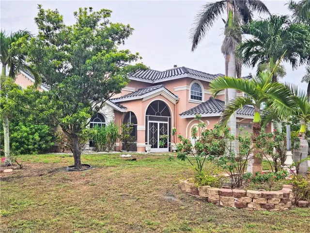 Mediterranean / spanish-style home featuring stucco siding, a tile roof, and a front yard
